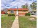 Charming brick home with a well-maintained lawn and walkway leading to the front door at 6990 Larsh Dr, Denver, CO 80221
