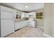 A well-lit kitchen showcases white cabinets, countertops, and appliances at 6990 Larsh Dr, Denver, CO 80221