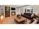 Bright, staged living room features hardwood floors, a fireplace, and a large bay window at 6990 Larsh Dr, Denver, CO 80221