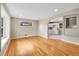 An open-concept living room boasts hardwood floors and access to a white kitchen at 6990 Larsh Dr, Denver, CO 80221