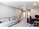 Bright bonus room featuring a comfortable couch and dedicated workspace at 13921 Scarlet Sage Ln, Parker, CO 80134