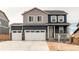 Charming two-story home featuring a three-car garage, stone accents, and a welcoming front porch at 13921 Scarlet Sage Ln, Parker, CO 80134