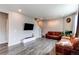 Open living room with hardwood floors, a large television, and cozy leather couches at 13921 Scarlet Sage Ln, Parker, CO 80134