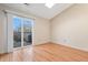 Bright bedroom with wood floors, vaulted ceiling, and sliding glass door to private balcony at 9612 W Chatfield Ave # C, Littleton, CO 80128