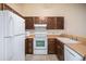 Functional kitchen featuring white appliances and wood cabinetry for a classic feel at 9612 W Chatfield Ave # C, Littleton, CO 80128