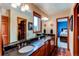 Bathroom featuring double sinks, dark countertops, wood cabinets and an open door to a bedroom at 8682 N Sundown Trl, Parker, CO 80134