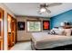 Cozy bedroom with a queen size bed, a ceiling fan and stylish decor on the light blue wall at 8682 N Sundown Trl, Parker, CO 80134