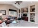 Cozy living room with vaulted ceilings, built-in shelving, and a large window with views of the backyard at 8682 N Sundown Trl, Parker, CO 80134
