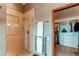 Shower with glass door and neutral tile work, and an open door to a walk-in closet at 8682 N Sundown Trl, Parker, CO 80134