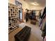 Spacious walk-in closet with custom shelving, hanging rods, and a plush ottoman at 8682 N Sundown Trl, Parker, CO 80134