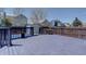 Spacious backyard deck with a dark blue trim, with a table and a backyard shed and pool at 4361 Kirk Ct, Denver, CO 80249