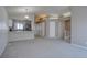 Open-concept living room featuring neutral tones, new carpet, and updated kitchen with stainless steel appliances at 4361 Kirk Ct, Denver, CO 80249