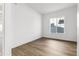 Clean bedroom with modern wood floors, base trim, and a bright window at 6653 Bridlespur St, Castle Pines, CO 80108