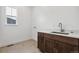 Laundry room featuring a sink with a white countertop and wooden cabinets at 6653 Bridlespur St, Castle Pines, CO 80108