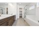 Main bathroom featuring a double vanity, a separate tub, and a shower with glass doors at 6653 Bridlespur St, Castle Pines, CO 80108