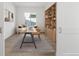 Well-lit home office with stylish desk, chair, shelving, and sitting area at 6653 Bridlespur St, Castle Pines, CO 80108