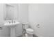 Powder room featuring a pedestal sink, a toilet, and a mirror at 6653 Bridlespur St, Castle Pines, CO 80108