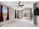 Large bedroom featuring vaulted ceilings, fan, multiple windows, and neutral colored walls and carpet at 10127 Bluffmont Ln, Lone Tree, CO 80124