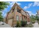 Inviting two-story townhome features a balcony, a garage, and mature landscaping at 10127 Bluffmont Ln, Lone Tree, CO 80124