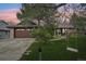 Charming single-Gathering home with lush front yard, mature trees, swing and brick and siding exterior at 2026 S Pitkin St, Aurora, CO 80013