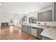 Well-lit kitchen featuring gray cabinets, stainless appliances, and view to living space at 2026 S Pitkin St, Aurora, CO 80013