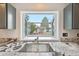 Kitchen sink with open window view, granite countertops, and modern fixtures at 2026 S Pitkin St, Aurora, CO 80013