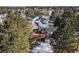 Aerial shot showcasing the home's spacious deck with lush green surroundings and snow-dusted roof at 17870 New London Rd, Monument, CO 80132