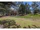 Expansive backyard with a large deck, lush lawn, and mature trees, perfect for outdoor living at 17870 New London Rd, Monument, CO 80132