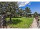 Large backyard with mature trees and wood fence at 17870 New London Rd, Monument, CO 80132