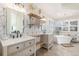 Bathroom boasting dual sinks, floating shelves, stylish light fixtures and a luxurious standalone tub at 17870 New London Rd, Monument, CO 80132
