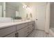 Modern bathroom with a spacious vanity, stylish mirror, and patterned floor tiles at 17870 New London Rd, Monument, CO 80132