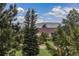 Home exterior with lush landscaping and mature trees at 17870 New London Rd, Monument, CO 80132