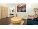 Inviting living room showcasing colorful artwork, a modern table, and comfortable seating near the bedroom entrance at 17870 New London Rd, Monument, CO 80132
