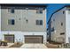 Townhome showing a two car garage, paved driveway, and neighboring properties at 2052 Alcott Way, Broomfield, CO 80023