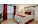 Cozy bedroom featuring hardwood floors, large window, and red accents at 20113 Edinborough Ct, Parker, CO 80138