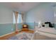 Light blue bedroom with hardwood floors, natural light and seating area at 20113 Edinborough Ct, Parker, CO 80138