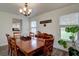 Well-lit dining room features hardwood floors, a stylish chandelier, and serene backyard view at 20113 Edinborough Ct, Parker, CO 80138