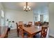 Bright dining room boasts a wooden table, decorative chandelier, and a view into the living area at 20113 Edinborough Ct, Parker, CO 80138