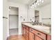 Well-lit bathroom with double sink vanity, modern fixtures, and access to a walk-in closet at 1628 Taos St, Brighton, CO 80603