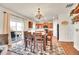 Bright dining area features wood floors, a modern light fixture, and sliding glass door to the outdoor patio at 1628 Taos St, Brighton, CO 80603