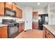 Bright kitchen with wooden cabinets, granite countertops, stainless steel appliances, and wood flooring at 1628 Taos St, Brighton, CO 80603