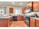 Modern kitchen with wooden cabinets, granite countertops, stainless steel appliances, and wood flooring at 1628 Taos St, Brighton, CO 80603