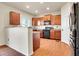 Well-lit kitchen with wooden cabinets, granite countertops, stainless steel appliances, and wood flooring at 1628 Taos St, Brighton, CO 80603
