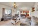 Spacious living room with an open floor plan, comfortable seating, a wooden chandelier, and lots of natural light at 1628 Taos St, Brighton, CO 80603