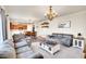 Open-concept living room with dining area and kitchen featuring hardwood floors and comfortable seating at 1628 Taos St, Brighton, CO 80603