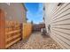 A compact utility side yard with gravel, an air conditioning unit, and a secure wooden fence for added privacy at 1628 Taos St, Brighton, CO 80603