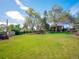 Sprawling backyard with green lawn, mature trees, and a view of the home's exterior at 164 W Acoma Dr, Littleton, CO 80120