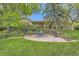 Well-maintained backyard featuring a stone patio, lush lawn, mature trees, and lovely landscaping for peaceful outdoor living at 164 W Acoma Dr, Littleton, CO 80120