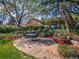 Backyard stone patio featuring an umbrella-shaded dining area and decorative landscaping, perfect for outdoor entertaining at 164 W Acoma Dr, Littleton, CO 80120