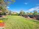 Large, well-maintained backyard with a lush green lawn, mature trees, lovely landscaping, and ample space at 164 W Acoma Dr, Littleton, CO 80120